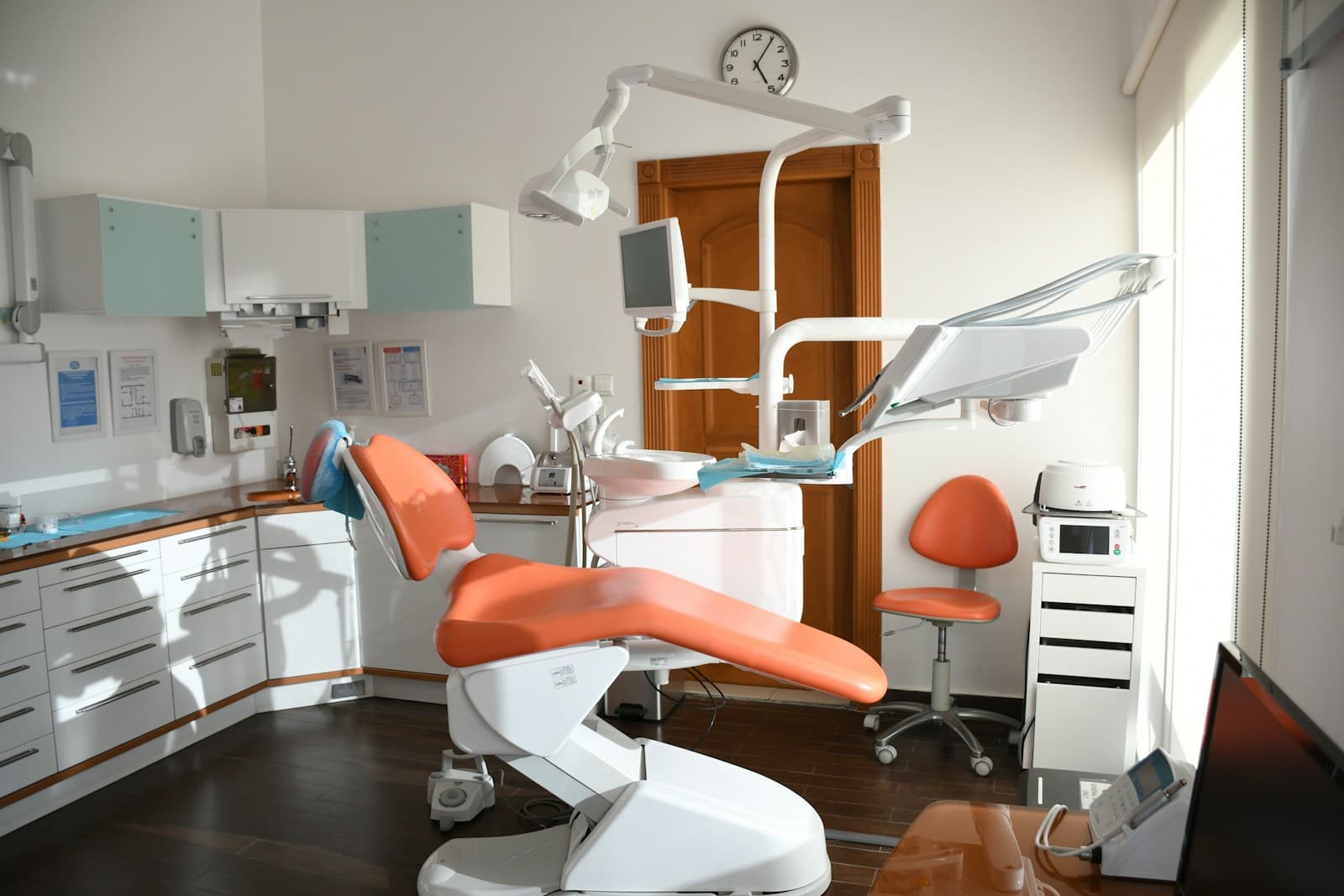 Sala de atendimento com cadeira odontológica laranja